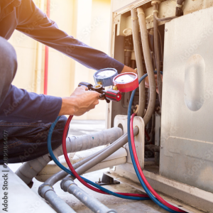 HVAC tech checking refrigerant next to an outdoor a/c unit performing an ac repair.